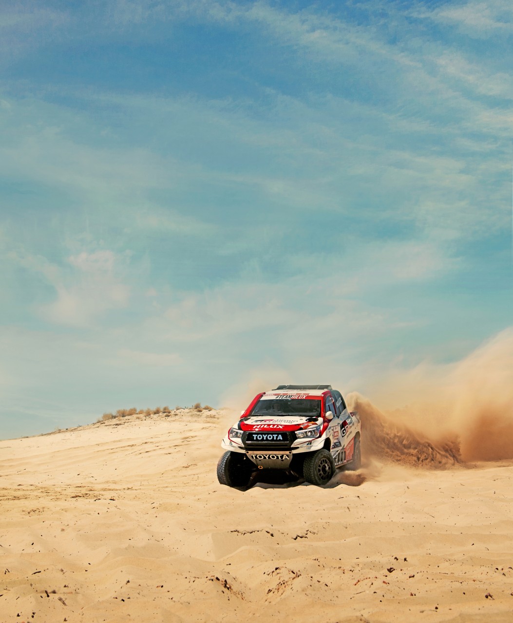 Rally car driving on a sandy road